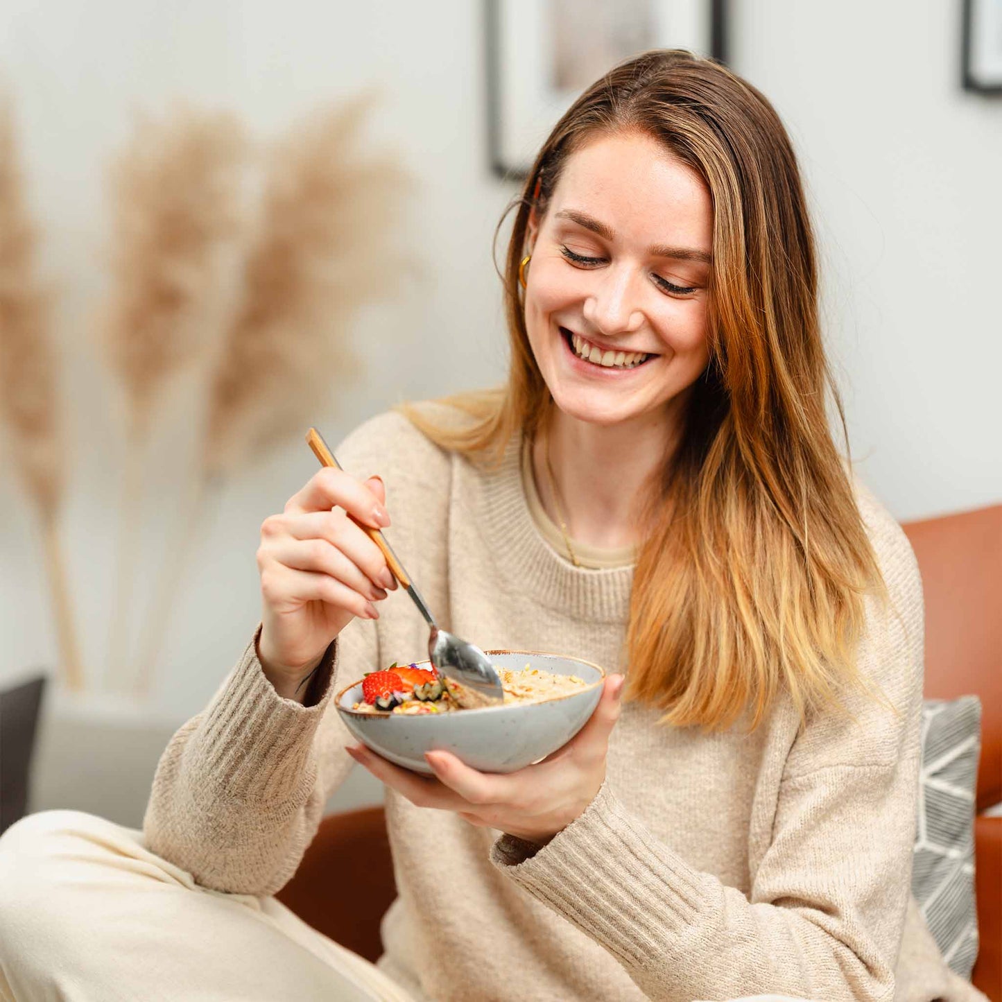 Lachender Kunde der eine zubereitete Smoothie Bowl isst